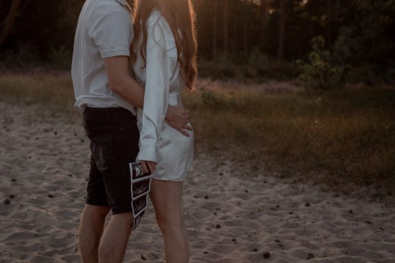 Koppel, verliefd, echo, lifestyle shoot Een stel dat elkaar vasthoudt op een zandige plek tijdens zonsondergang.